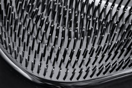 Close-up of bristles on black hairbrush. Black background.の写真素材