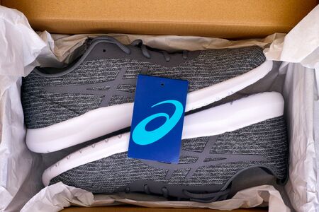 Tambov, Russian Federation - April 16, 2019 New gray Asics running shoes in box. Studio shot.のeditorial素材