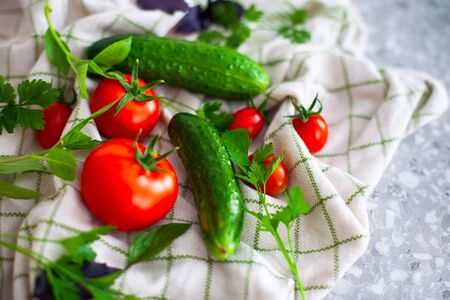 Tomatoes, cucumbers, basil and parsley on kitchen towel. Close-up.の写真素材