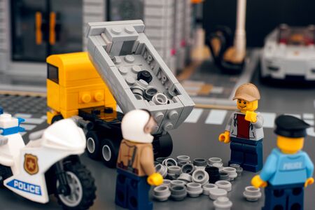 Tambov, Russian Federation - October 21, 2019 Lego dump truck dumping out load onto road due to road accident. Police investigate. Studio shot.のeditorial素材
