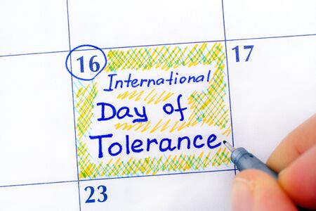 Woman fingers with pen writing reminder International Day of Tolerance in calendar. November 16.の写真素材