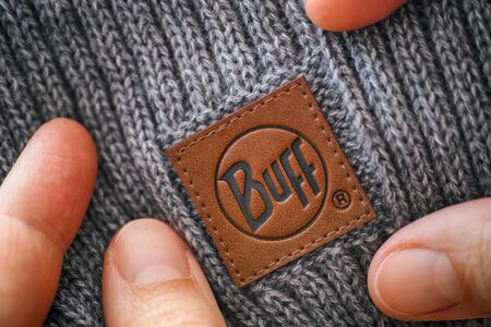 Tambov, Russian Federation - November 16, 2019 Knitted hat with clothes label Buff in woman hands....