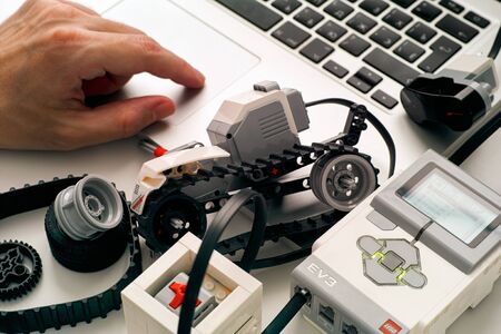 Tambov, Russian Federation - December 25, 2019 Persons hand coding  LEGO MINDSTORMS EV3 robot blocks on laptop.のeditorial素材