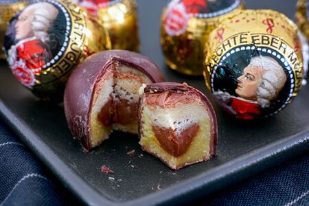 Tambov, Russian Federation - February 14, 2020 Mozart candies on black plate.  One candy is open and cutのeditorial素材