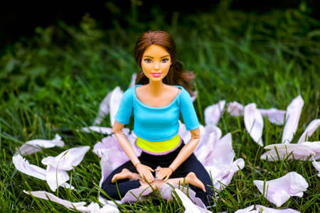 Tambov, Russian Federation - June 12, 2020 Brunette Barbie doll sitting in the yoga lotus posture...