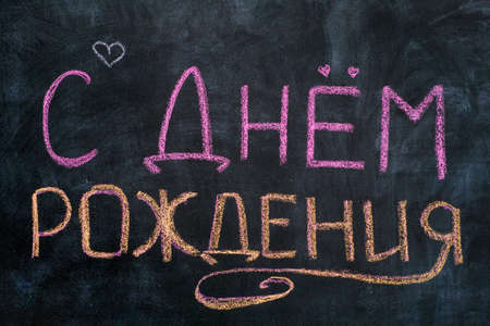 Ð¡ Ð´Ð½ÐµÐ¼ ÑÐ¾Ð¶Ð´ÐµÐ½Ð¸Ñ. Words Happy Birthday written in Russian language on blackboard.の写真素材