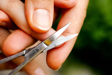Woman hold child finger and cutting fingernail by nail scissors.の写真素材