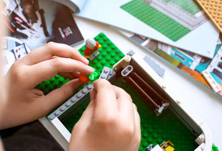 Tambov, Russian Federation - June 20, 2020 Child building Lego house on the table with instruction books. Shallow depth of fieldのeditorial素材