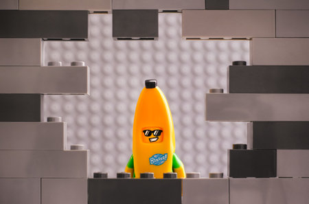 Tambov, Russian Federation - August 26, 2020 Lego Banana Guy minifigure looking through a hole in...