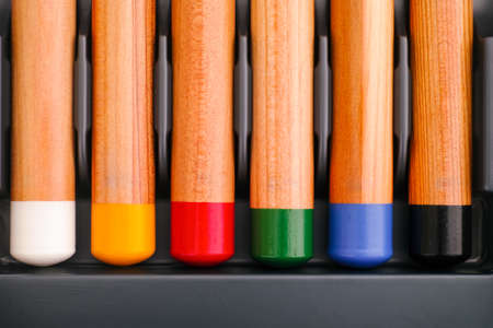 The bottoms of six colored pencils in a row in gray trayの写真素材