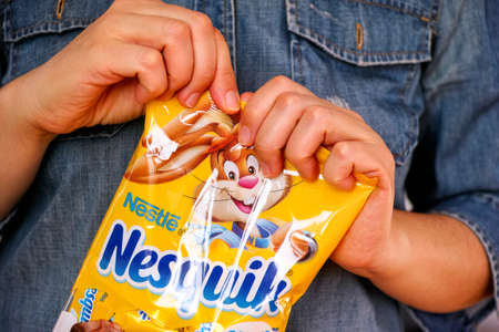 Tambov, Russian Federation - January 30, 2021 Woman hands ready to open Nesquik candies packのeditorial素材