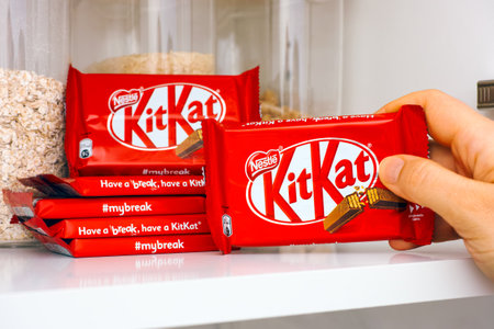 Tambov, Russian Federation - March 19, 2021 Woman hand taking KitKat chocolate bar by Nestle from...