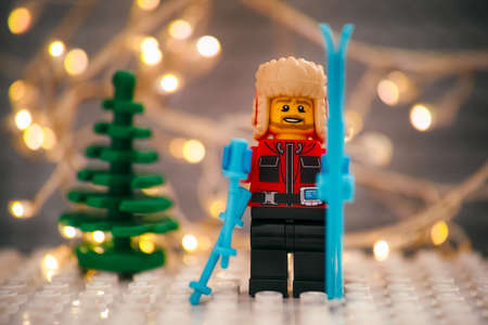 Tambov, Russian Federation - January 17, 2021 Lego skier minifigure with skis against Christmas tree and christmas light backgroundのeditorial素材