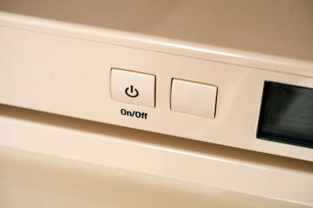 Close-up of on off button on a beige fridge