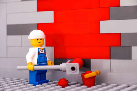 Tambov, Russian Federation - January 17, 2021 painter minifigure painting a wall red. Close-up.のeditorial素材