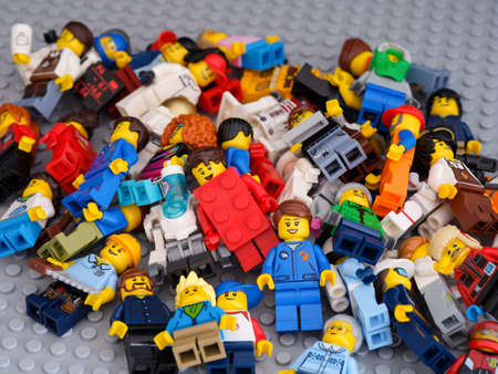 Tambov, Russian Federation - July 16, 2021 Many Lego minifigures lying in a heap on Lego gray baseplateのeditorial素材