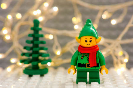 Tambov, Russian Federation - January 17, 2021 Lego Elf minifigure against Christmas tree and Christmas light backgroundのeditorial素材