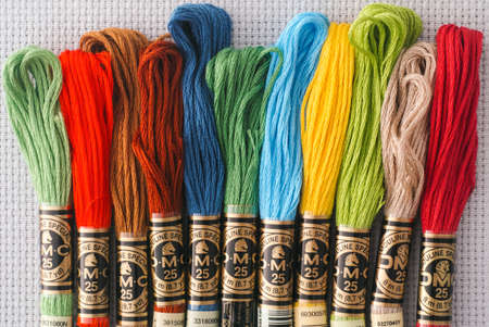 Tambov, Russian Federation - October 20, 2020 Different colors DMC Six Strand Floss in a row on white canvas background.のeditorial素材
