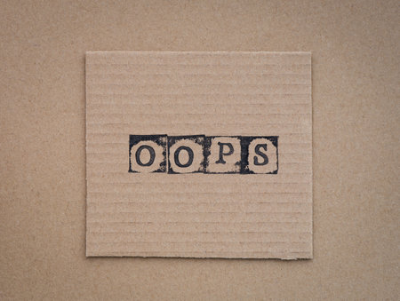 Cardboard with word Oops made by black alphabet stamps.の写真素材