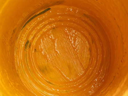 Close up inside of empty bucket of yellow paint.