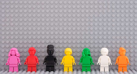 Tambov, Russian Federation - August 12, 2021 Seven Lego monochrome minifigures standing in a row against a gray Lego baseplate background.のeditorial素材