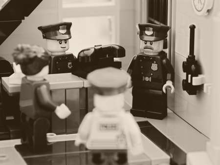 Tambov, Russian Federation - August 02, 2021 Four Lego police officers having a discussion near an old telephone in a police station. Black and white.のeditorial素材