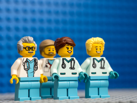 Tambov, Russian Federation - February 12, 2022 Four Lego doctor minifigures standing against a blue baseplate backgroundのeditorial素材