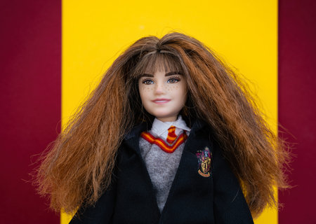 Tambov, Russian Federation - February 15, 2022 Portrait of a Mattel Harry Potter Hermione Granger Doll against red and yellow Gryffindor colors background.のeditorial素材