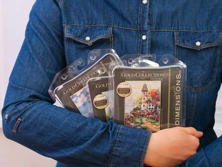 Tambov, Russian Federation - December 23, 2021 A Woman holding three Cross Stitch Kits by Dimensions...