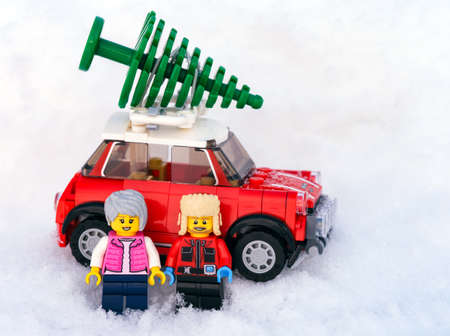 Tambov, Russian Federation - January 19, 2022 Two Lego minifigures standing in front of a red car...