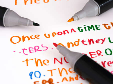 Three markers laying on a piece of paper with a story that is in a childs handwriting Once upon a...