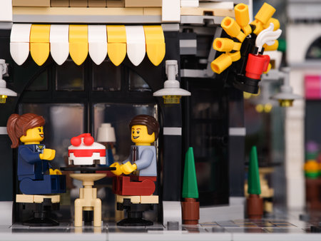 Tambov, Russian Federation - January 07, 2023 A Lego businessman and businesswoman minifigures sitting behind a table at a street cafe and eating a cakeのeditorial素材