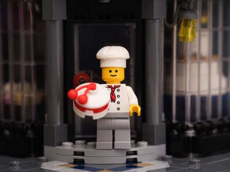 Tambov, Russian Federation - January 14, 2023 A Lego pastry chef minifigure with a cake standing on the doorstep of a bakeryのeditorial素材