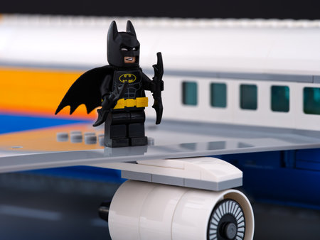 Tambov, Russian Federation - February 18, 2023 A Lego Batman minifigure standing on the wing of a passenger airplaneのeditorial素材