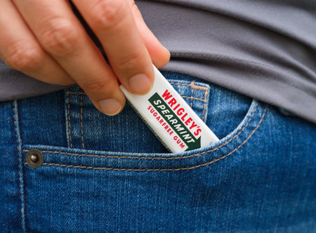 Tambov, Russian Federation - May 12, 2023 A woman taking a pack of Wrigley's spearmint gum out of a...