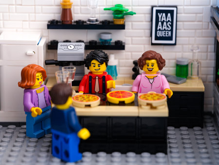 Tambov, Russian Federation - June 22, 2023 Four Lego minifigures in a kitchen and making pizzas