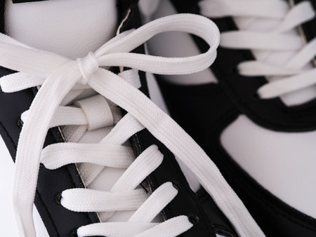 A close-up shot of two black and white shoes with tied shoe lacesの写真素材