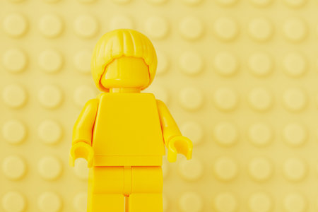 Tambov, Russian Federation - October 31, 2023 Portrait of a yellow Lego minifigure against a yellow baseplate background.のeditorial素材