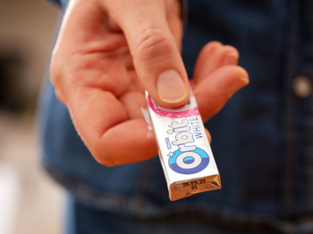 Tambov, Russian Federation - December 20, 2023 A woman giving a pack of Orbit chewing gum.のeditorial素材