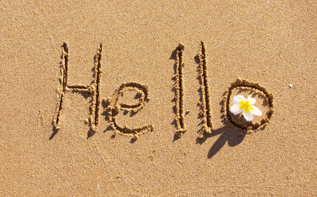 The word Hello written in sand on a beachの写真素材