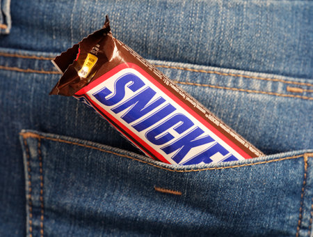 Tambov, Russian Federation - January 23, 2024 Snickers chocolate bar in a jeans back pocketのeditorial素材