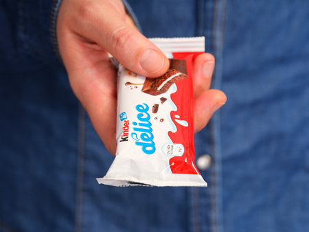 Tambov, Russian Federation - January 23, 2024 A woman holding out a Kinder Delice cake bar.のeditorial素材