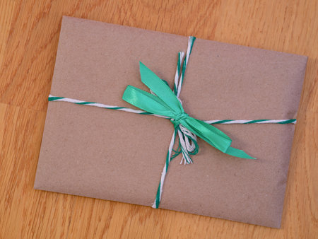 A gift with a green bow on a wooden background.の写真素材
