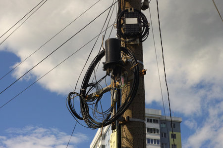 Optical cables hanging on a power pole.