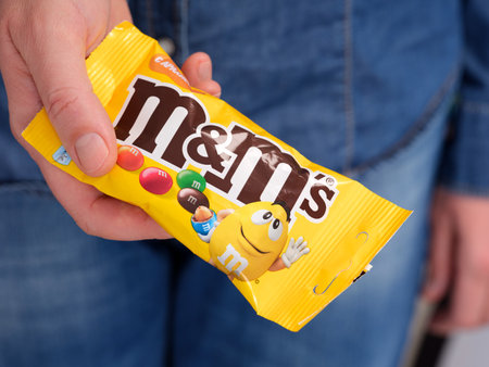 Tambov, Russian Federation - January 23, 2024  A woman holding out M&Ms packのeditorial素材