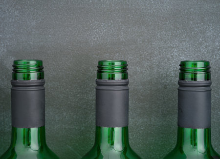 Three open wine bottles standing in a row against black background.の写真素材