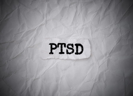Crumpled piece of paper with letters PTSD on a crumpled white paper background.の写真素材