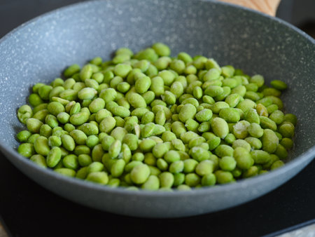 Frozen green Edamame soy beans in a frying pan ready to be cookingの写真素材