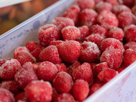 Frozen strawberries in a plastic container. Close-upの写真素材