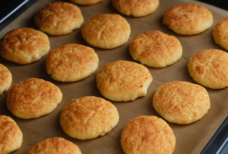 Close-up shot of a baking tray with curd cheese pancakes (syrniki).